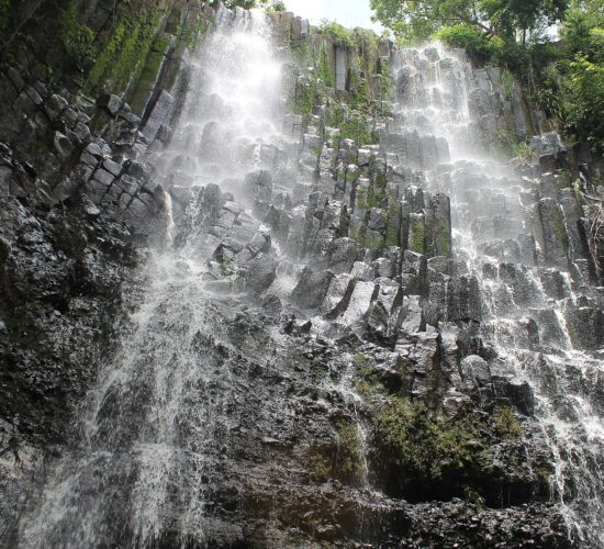 Los Tercios waterfall flowing over basalt columns near Suchitoto